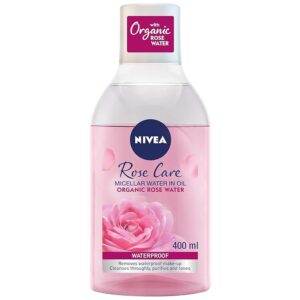 An image of Nivea Rose Care Micellar Water in Oil. The bottle is 400ml and has a pink lower half with a clear upper section, featuring the Nivea logo and labeling that highlights the inclusion of organic rose water. The product is indicated to be waterproof and is designed for removing waterproof makeup, cleansing thoroughly, purifying, and toning the skin